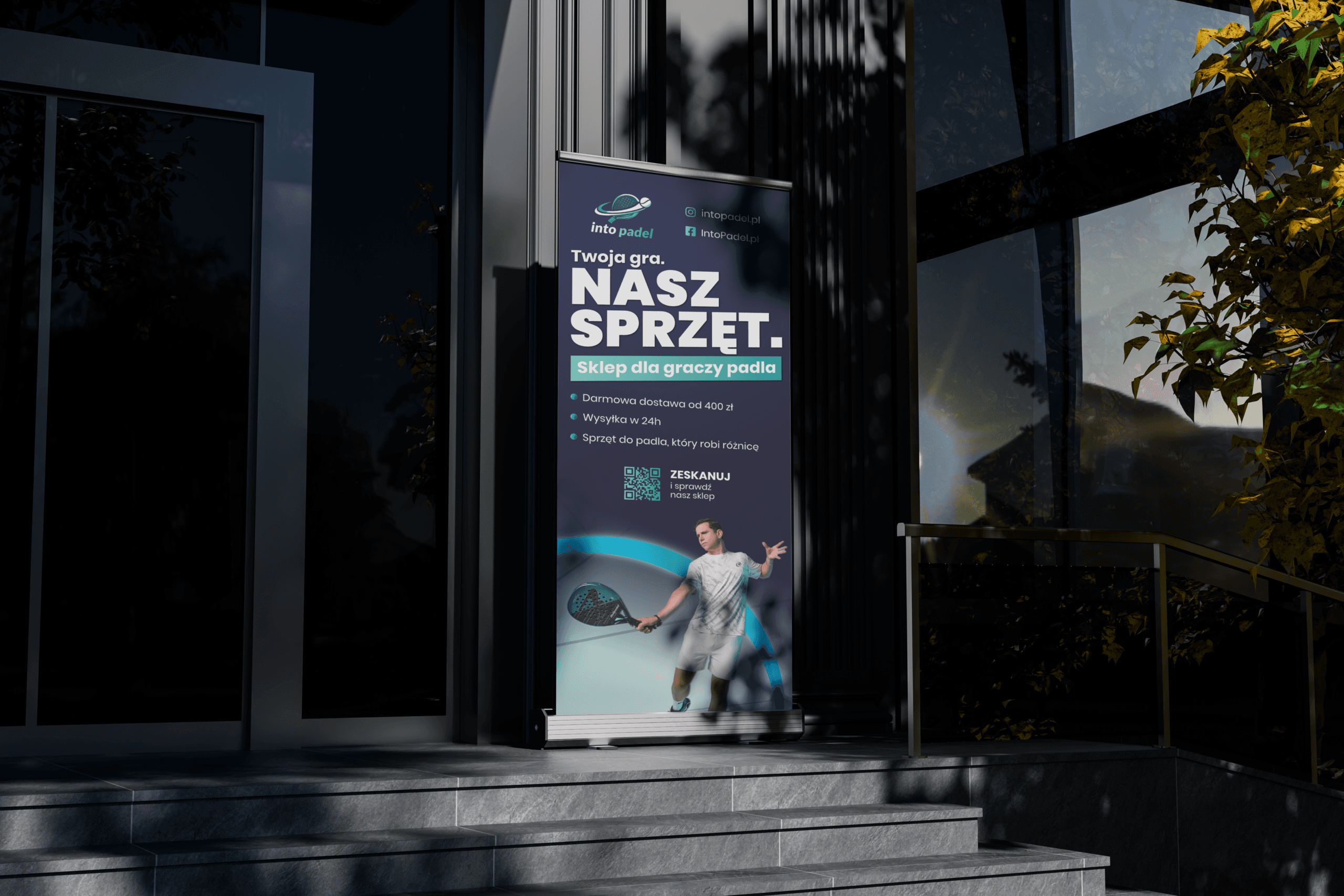 Roll-up reklamowy sklepu do padla przy wejściu do budynku, z hasłem „NASZ SPRZĘT”.